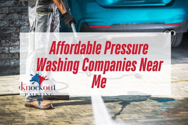 A-technician-uses-a-pressure-washer-to-clean-a-driveway-with-water-spraying-across-the-brick-surface